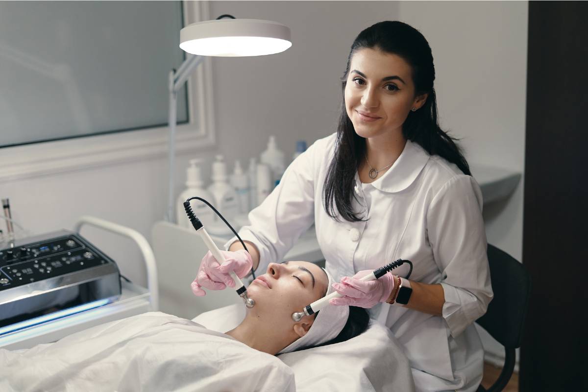 An aesthetic nurse practitioner performs a treatment on a patient.