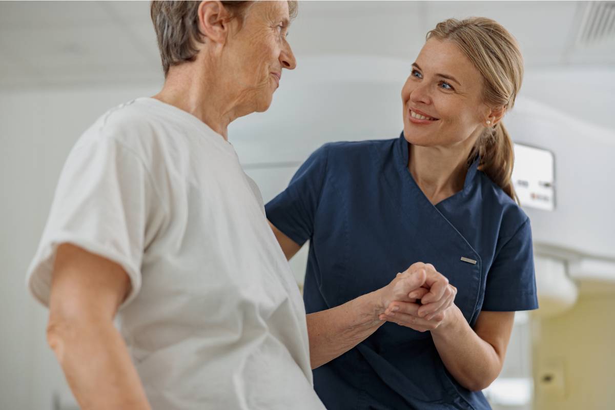 An NP with AOCNP certification assists an oncology patient during a check-up.