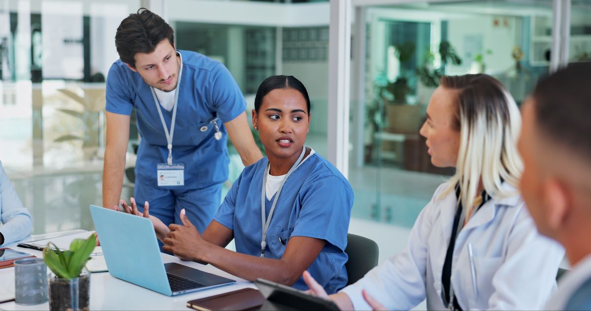A nurse fills out an assignment despite objection (ADO) form while discussing it with her colleagues.