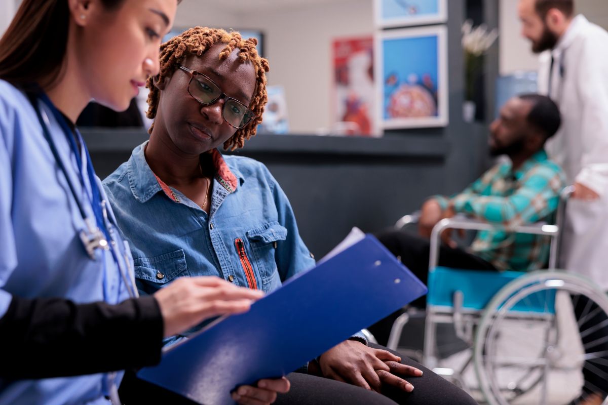 Two nurses using a clinical judgment model to help a patient.