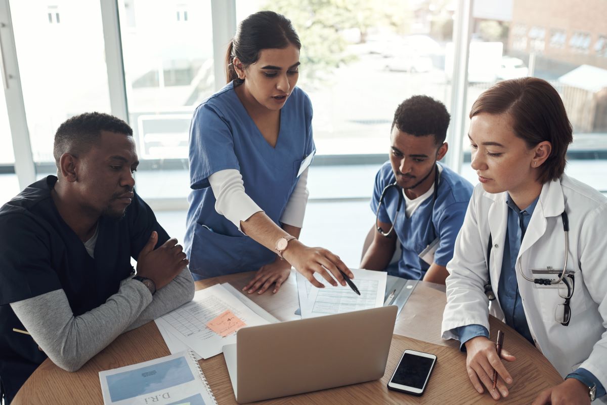 A clinical nurse leader discusses new guidelines with other members of her care team.