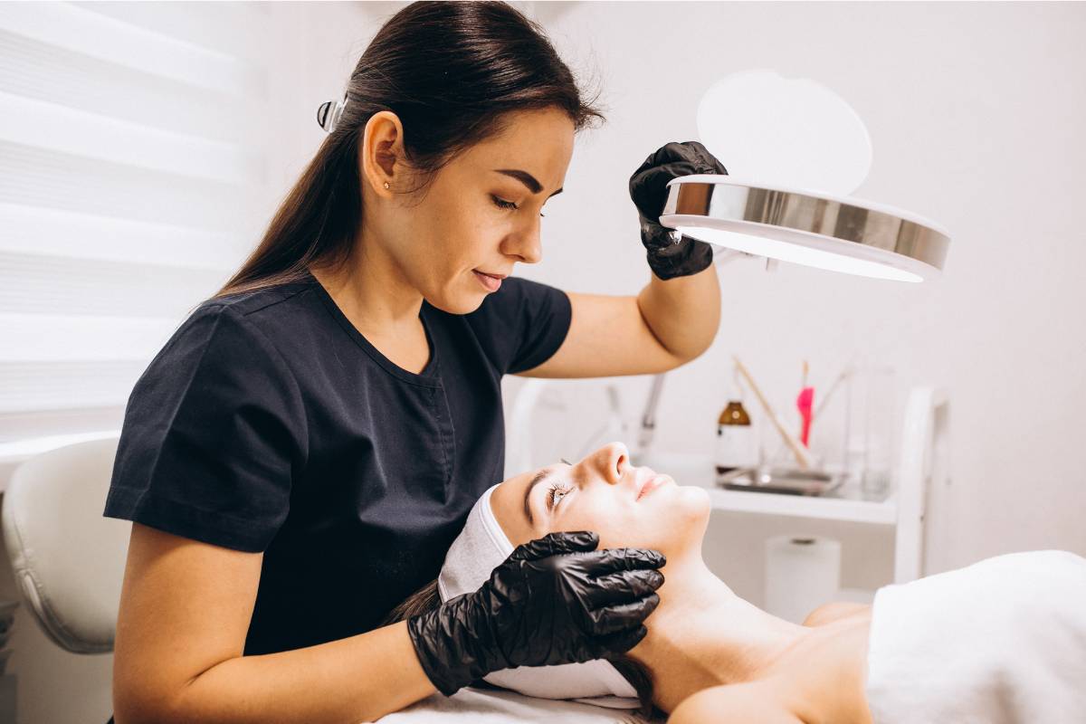 A nurse practitioner with DCNP certification assesses a patient's skin.