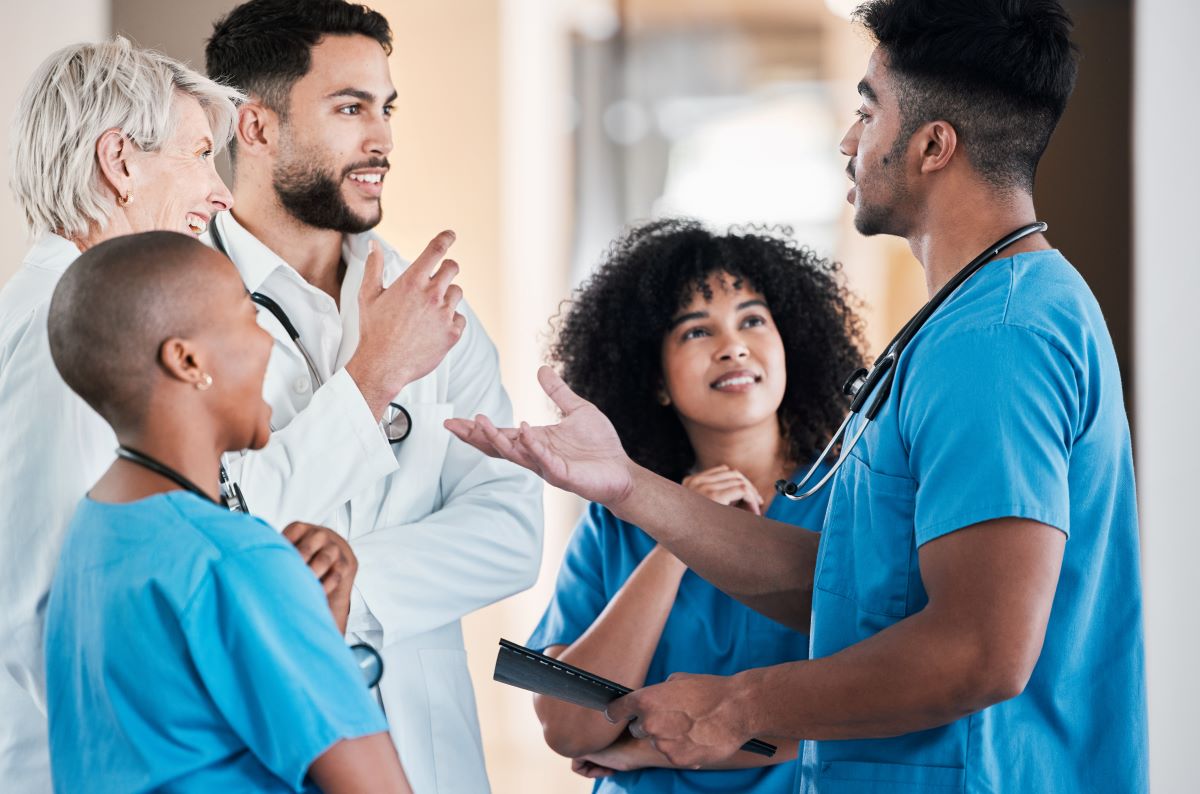 A diverse group of nurses and physicians have a discussion.