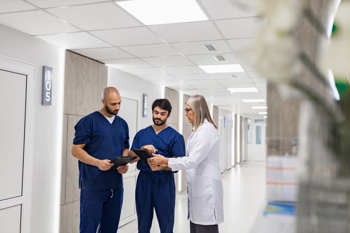 Two nurses and a physician review a patient's EHR summary.