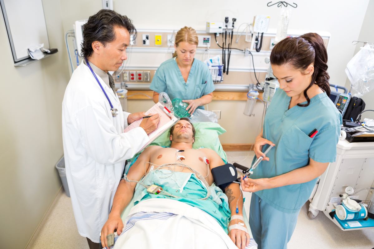 Emergency nurses assist a patient.