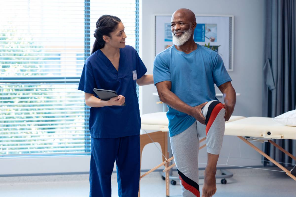A nurse helps a patient with their exercises while discussing how to become a registered nurse in Georgia.