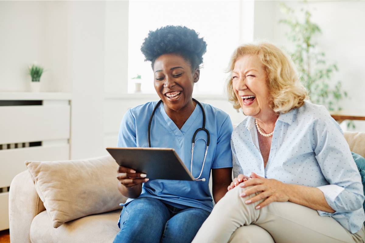 A nurse relies on humor in nursing to lighten the mood with a patient during a home visit.