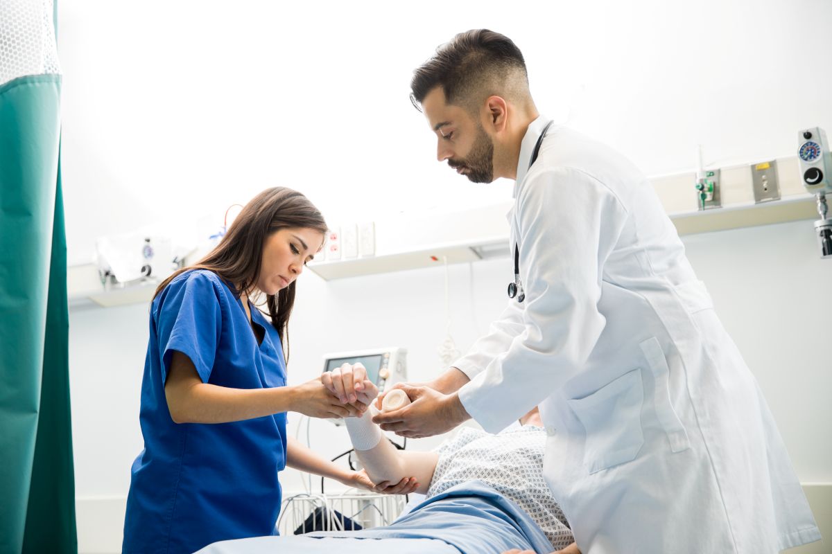 An ER nurse and a physician attend to a patient.
