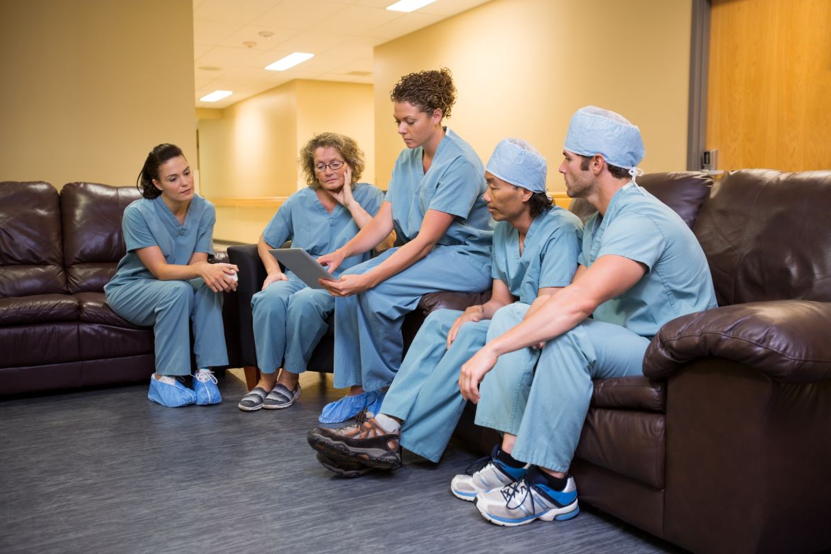A team of nurses conducts a nurse SWOT analysis in a break room.