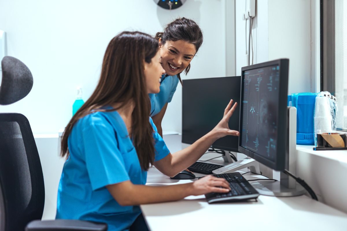 Coworkers have a discussion at the nurses' station.