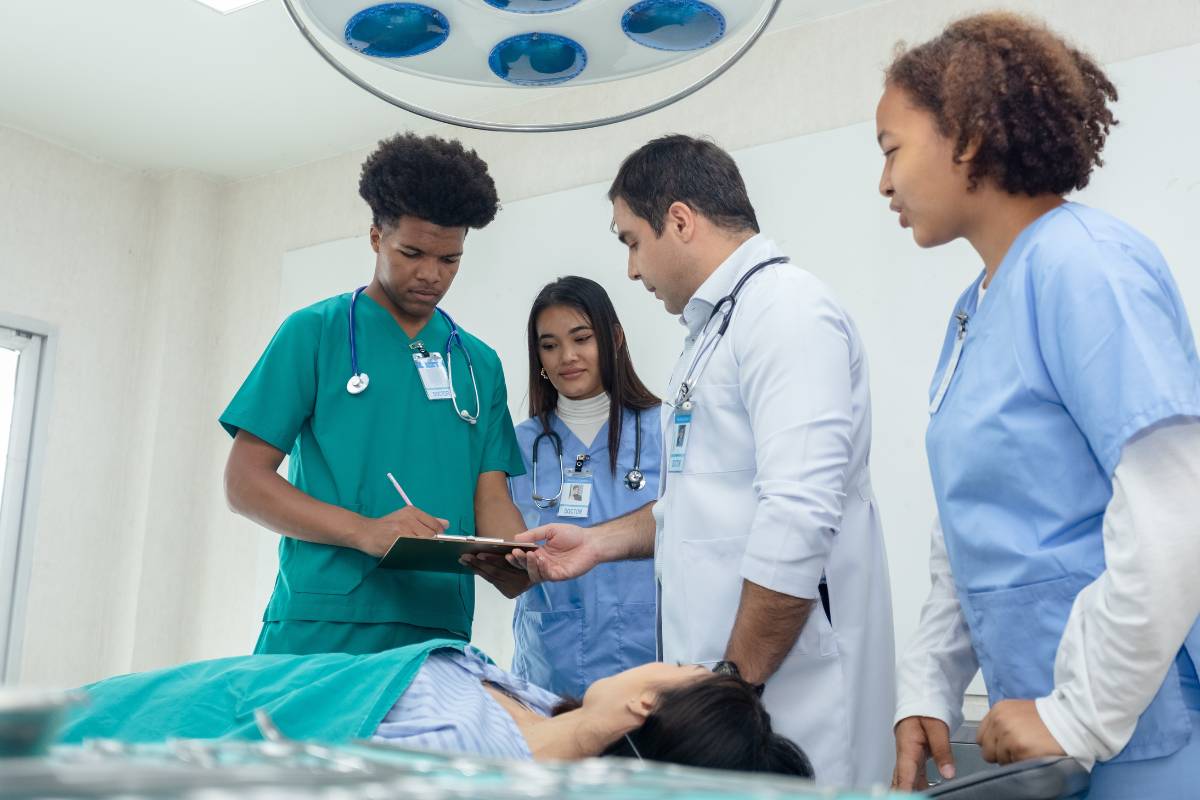 A group of nursing students reviews nursing medical terminology with their professor.