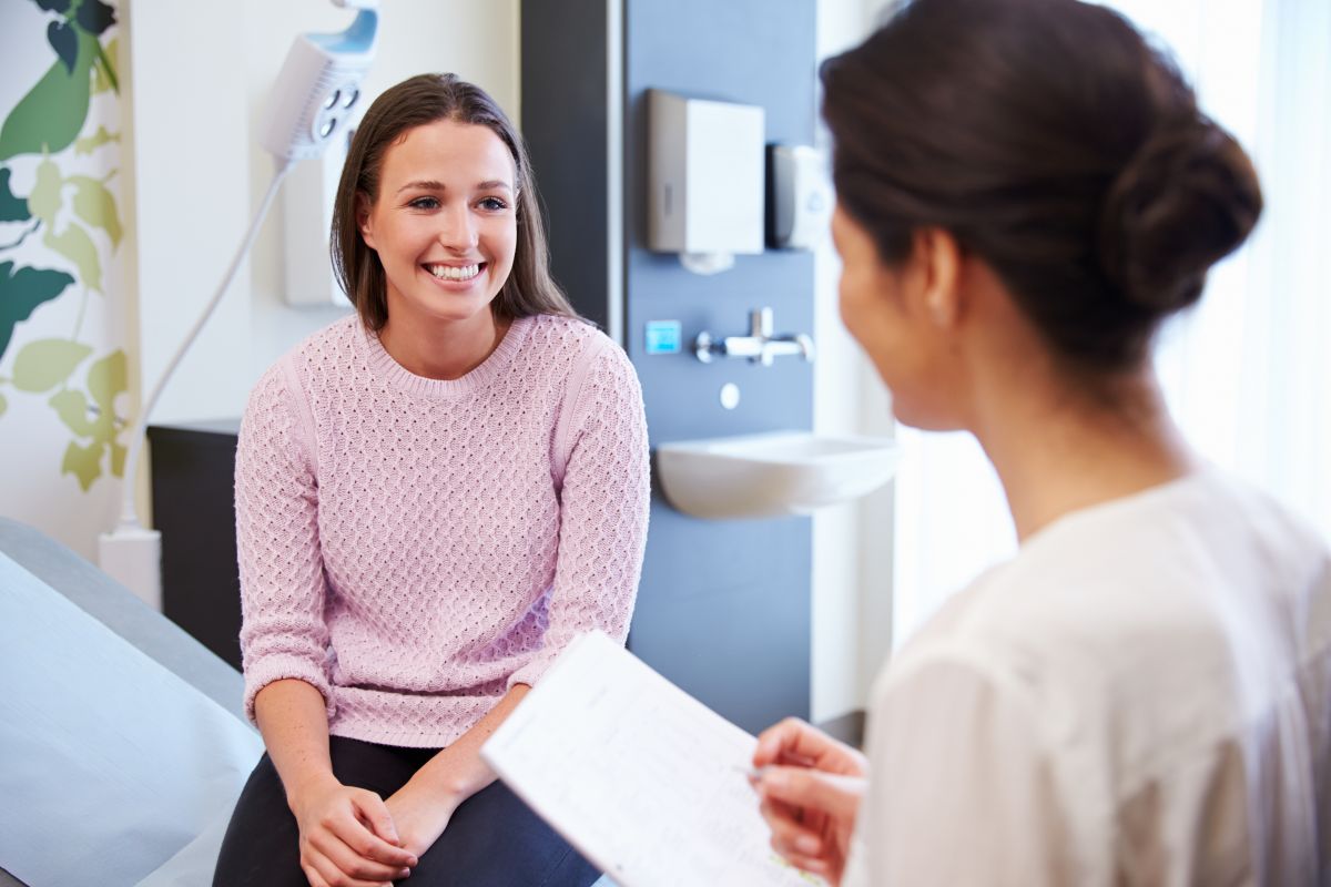 A patient access representative speaks with a client about her care.