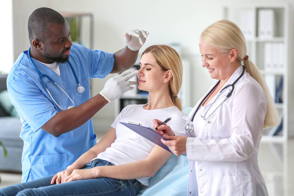 A plastic surgery nurse practitioner assesses a patient before a procedure.