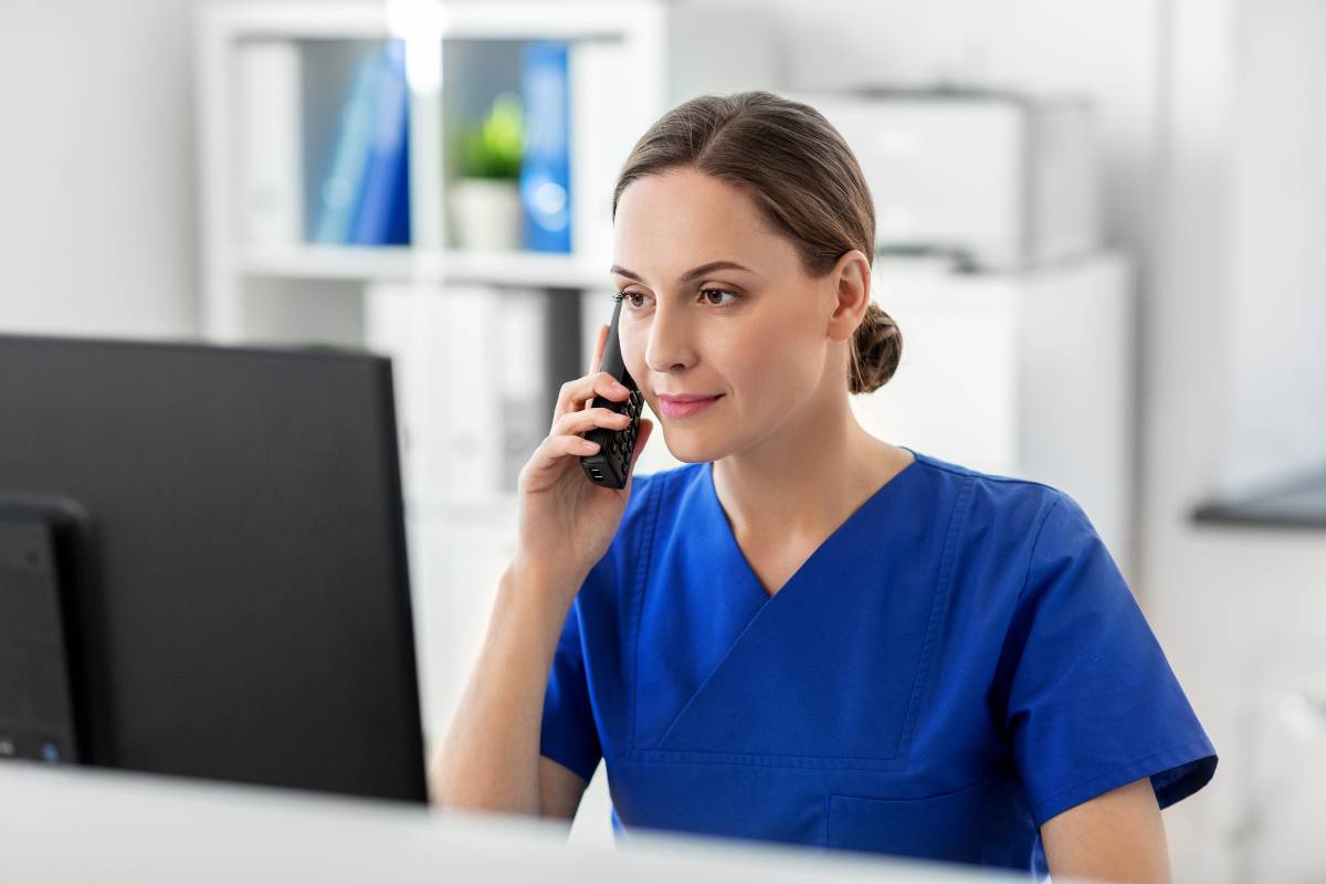 A public health nurse analyzes assessment data while talking on the phone.