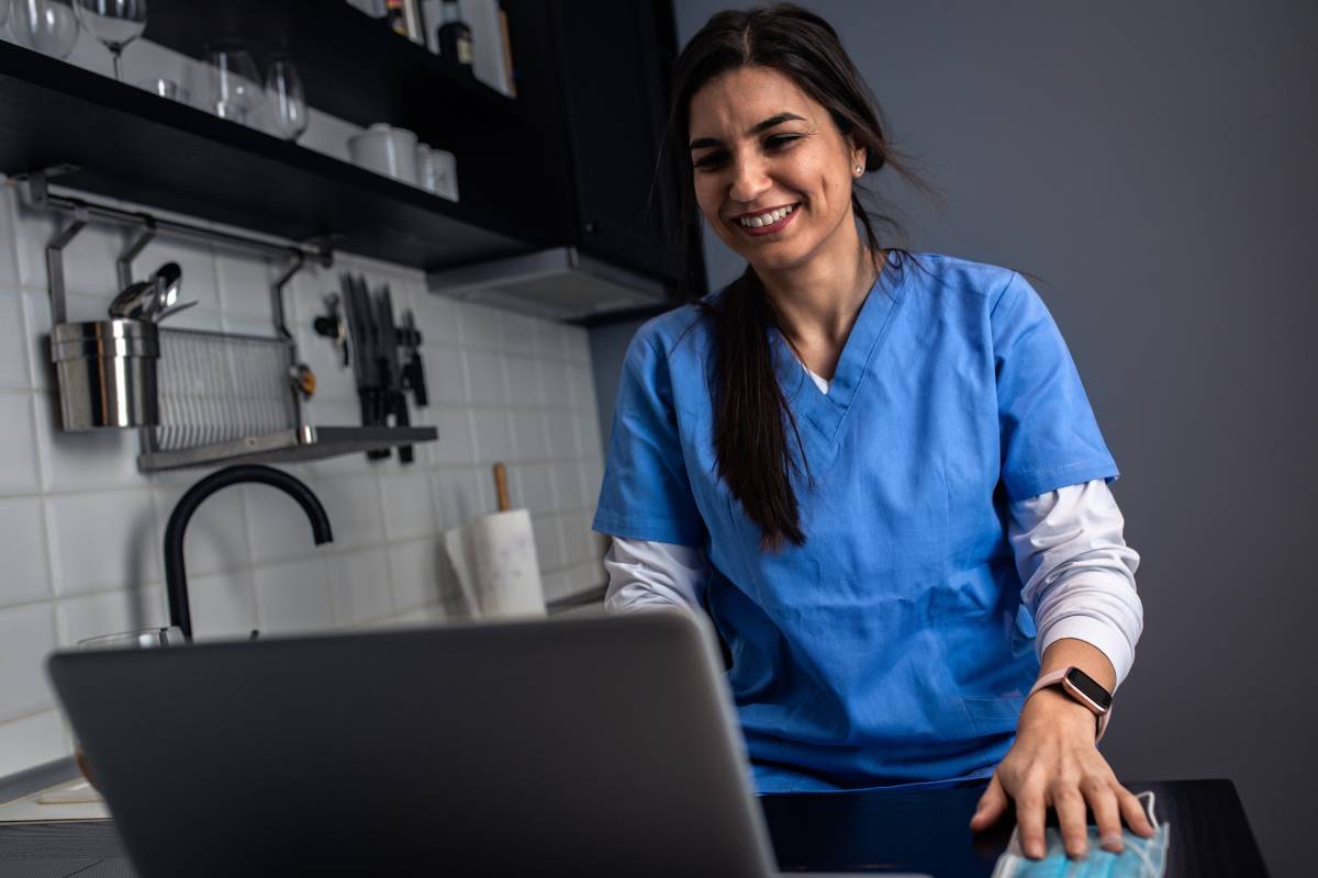 A telehealth nurse practitioner meets with a patient on a video call from home.