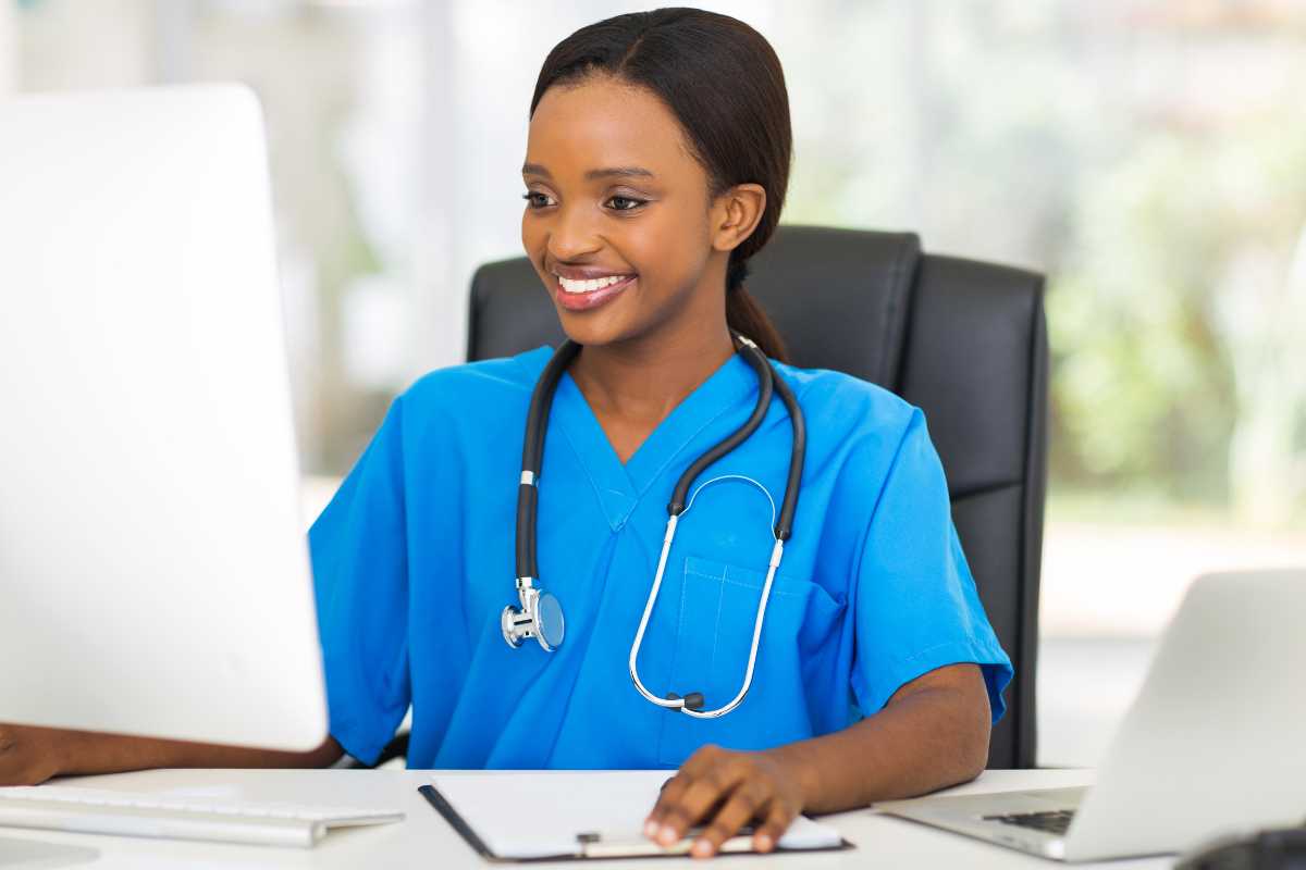 Nurse working at laptop to complete the Texas board of nursing license renewal.