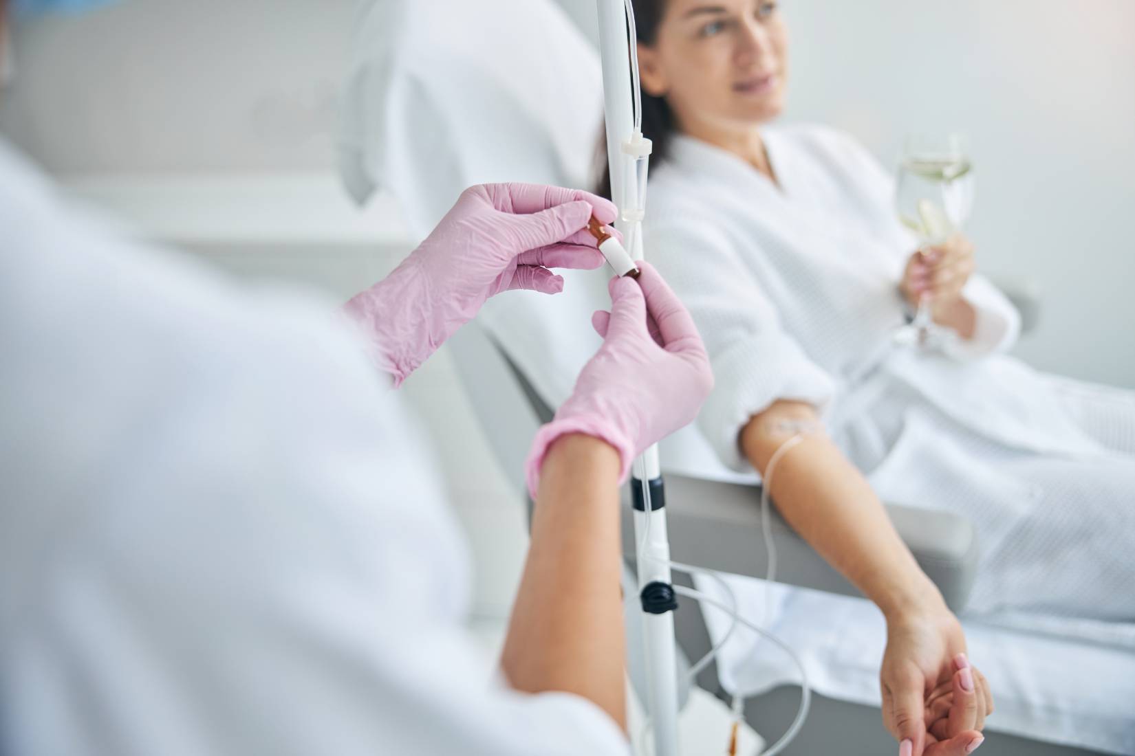A nurse with VA-BC certification adjusts an IV line.