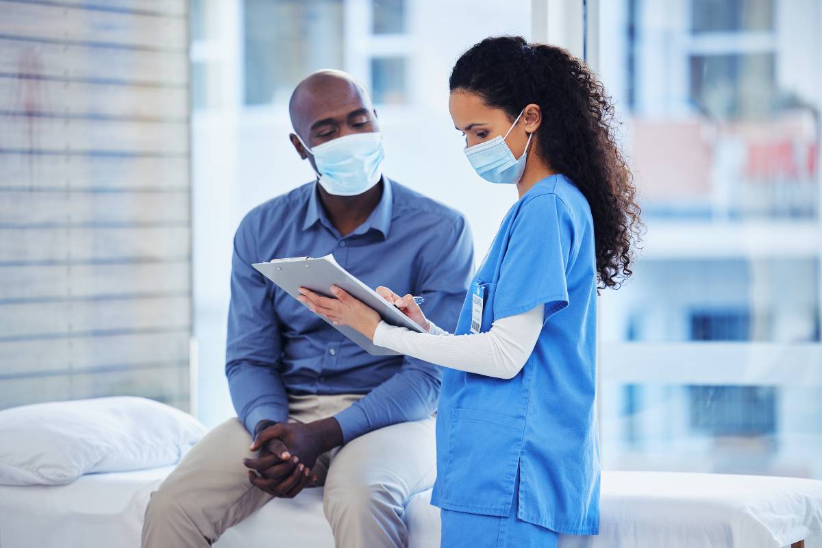 A nurse demonstrates, What is a nursing implcation, as she mitigates infection risk with a patient.